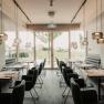 Das Restaurant, © Philipp Blickfang Modernes Restaurant mit eleganter Einrichtung und großen Fenstern.