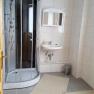 Badezimmer, © Haus Nova Modernes Badezimmer mit Dusche, Waschbecken und Spiegel.