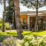 aussen01, © Hotel Garni Steinfeld Eingang eines modernen Gebäudes mit Garten und Bäumen.