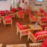 Lounge, © Winrooms Betriebs GmbH Eine Lounge mit roten Sesseln und Holztischen auf Holzboden.