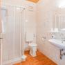 bad, © Hotel Garni Steinfeld Ein Badezimmer mit Dusche, Toilette und Waschbecken.