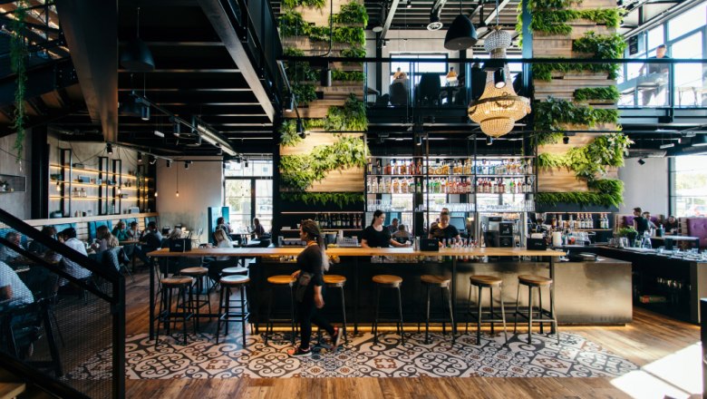 Die Bar, © Le Burger Innenansicht einer modernen Bar mit Pflanzenwänden und Kronleuchter.