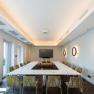 The seminar room, © Philipp Blickfang Modern seminar room with U-shaped table arrangement, chairs, a large screen and decorative wall lamps.