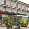 Orange Wings Front, © Wiener Alpen/Katrin Zeleny Moderne Hotel-Fassade mit Glasfront und Pflanzen.