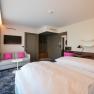 Suite mit Blick zum Schneeberg, © Philipp Blickfang Moderne Hotelsuite mit Doppelbett, Sofa, Fernseher und Schreibtisch.