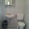 Badezimmer, © Haus Nova Kleines Badezimmer mit Waschbecken, Spiegel, Toilette und Mülleimer.