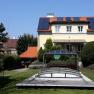 Haus mit Pool, © bed and pool Ein Haus mit Solarpanelen und einem überdachten Pool im Garten.
