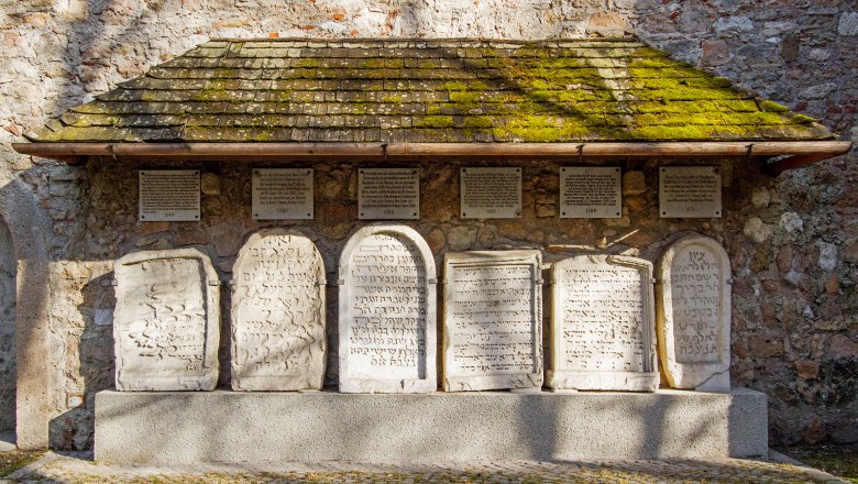 Jewish gravestones, © Michael Weller Jewish gravestones on a stone wall with a moss-covered roof.