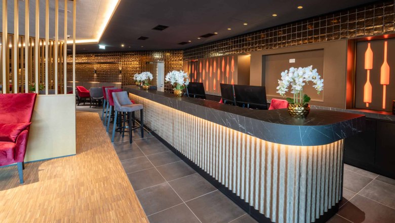 Rezeption, © Plaza Hotelgroup Moderne Hotelrezeption mit stilvoller Beleuchtung und Dekoration.
