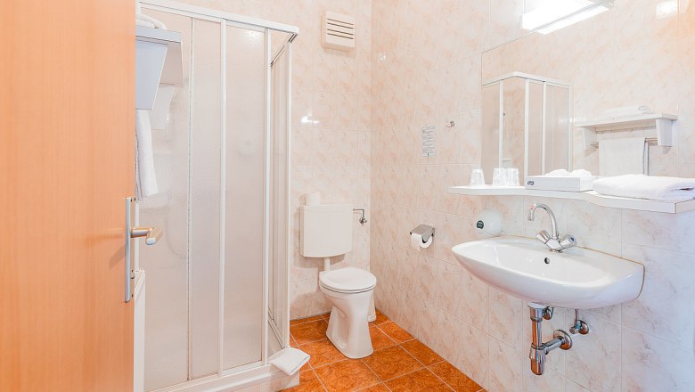 bad, © Hotel Garni Steinfeld Ein Badezimmer mit Dusche, Toilette und Waschbecken.