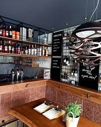 Al Duomo, © Al Duomo Innenansicht eines modernen Restaurants mit Weinregalen und Tafeln an den Wänden.