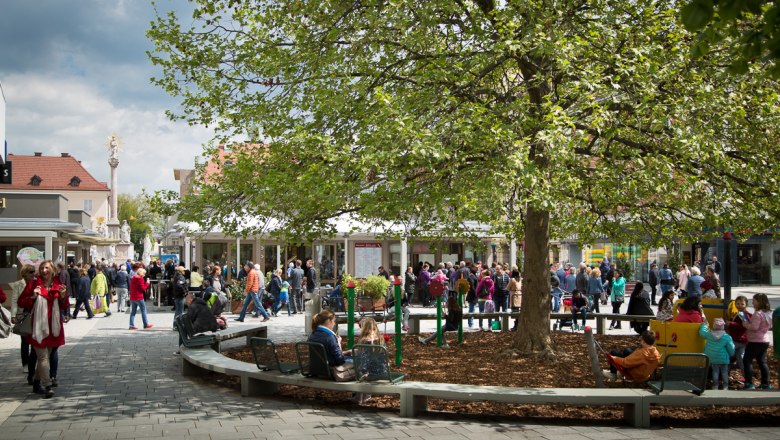 Marienmarkt vom Spielplatz aus, © WNSKS Menschenmenge auf einem Marktplatz mit Bäumen und Spielplatz.