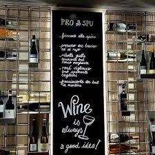 Al Duomo, © Al Duomo Weinregal mit Kreidetafel und Weinflaschen.