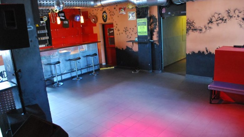 The engine from the inside., © c Triebwerk Interior view of an empty nightclub with bar, stools and ventilation pipes.