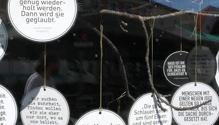 Round signs with quotes hang in a shop window.