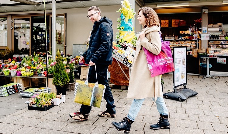 2 Menschen die über den Markt schlendern.