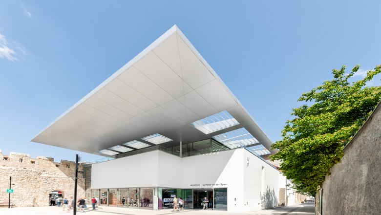 Modern building of the St. Peter an der Sperr Museum with a large canopy and glass façade.