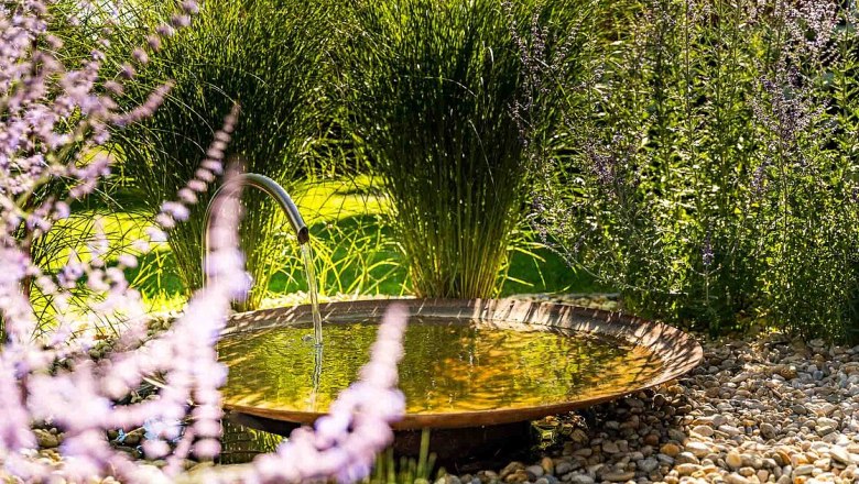 Garten mit kleinem Brunnen und Lavendel im Vordergrund.