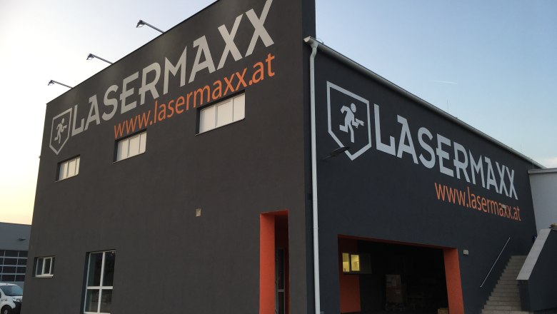 Außenansicht eines Gebäudes mit der Aufschrift 'LASERMAXX' und einer Website-Adresse.