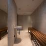 Modern sauna area with wooden benches and washbasin.