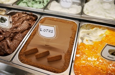 Eissorte „Lotus“ mit Keksstücken in einer Verkaufsvitrine.