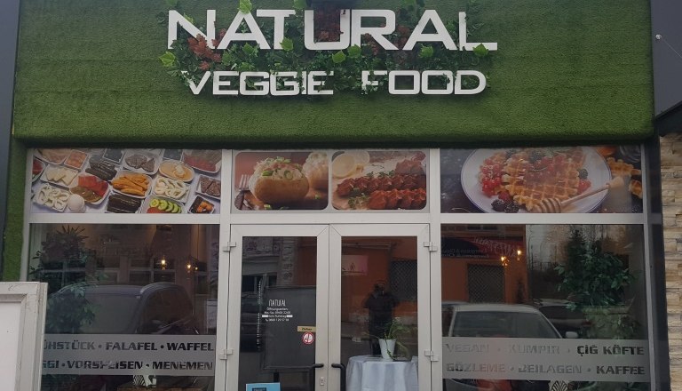 Eingang eines Restaurants mit dem Namen 'Natural Veggie Food'.