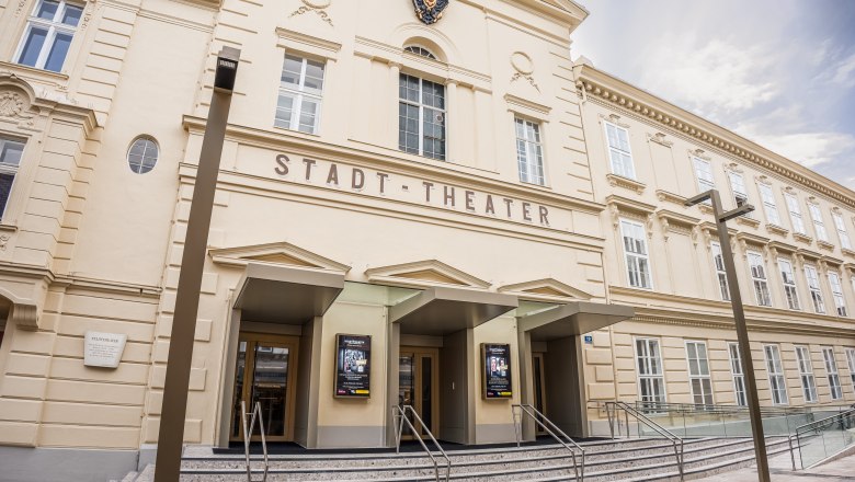 Fassade des Stadttheaters Wiener Neustadt mit historischer Architektur, drei Eingängen und moderner Glasrampe