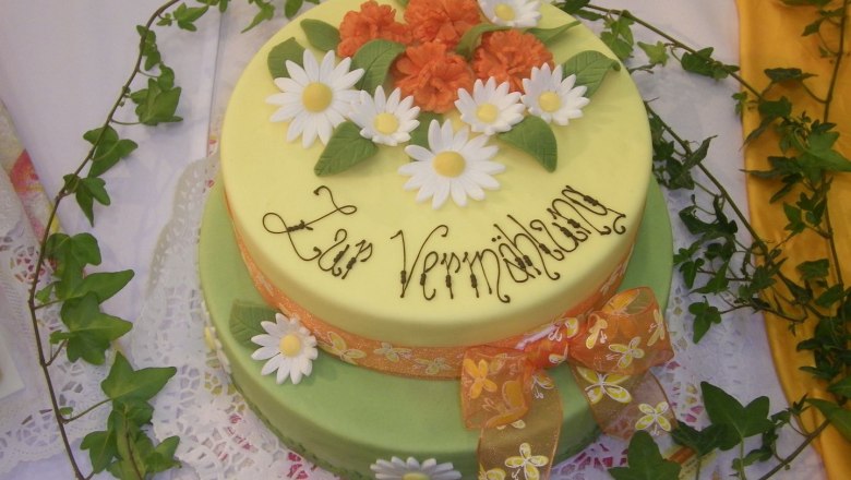 Two-tier cake with flowers and 'Zur Verm&auml;hlung' lettering.
