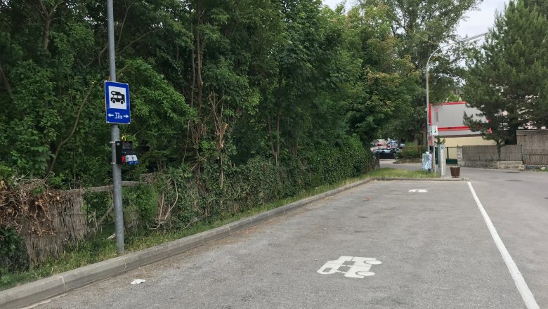 Parkplatz f&uuml;r Wohnmobile mit Stromanschluss, umgeben von B&auml;umen.