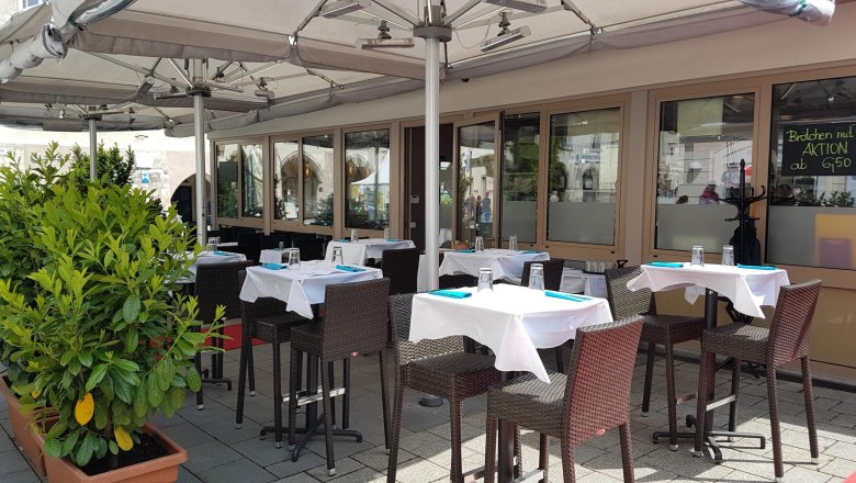 Outdoor area of a restaurant with covered tables and parasols.