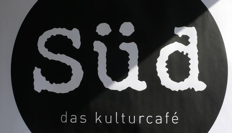 Logo of the Kulturcaf&eacute; S&uuml;d with white lettering on a black circle.