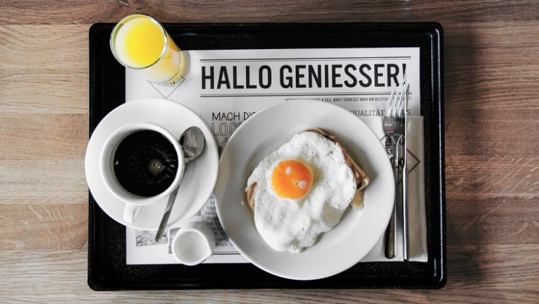 Frühstückstablett mit Kaffee, Spiegelei auf Toast und Orangensaft.