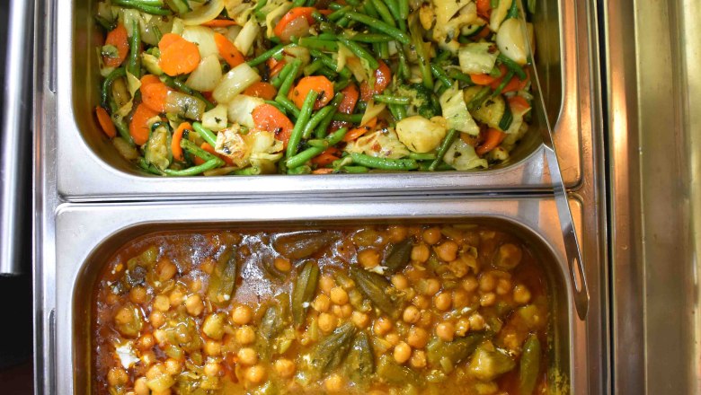 Two different Indian vegetable dishes in metal containers.