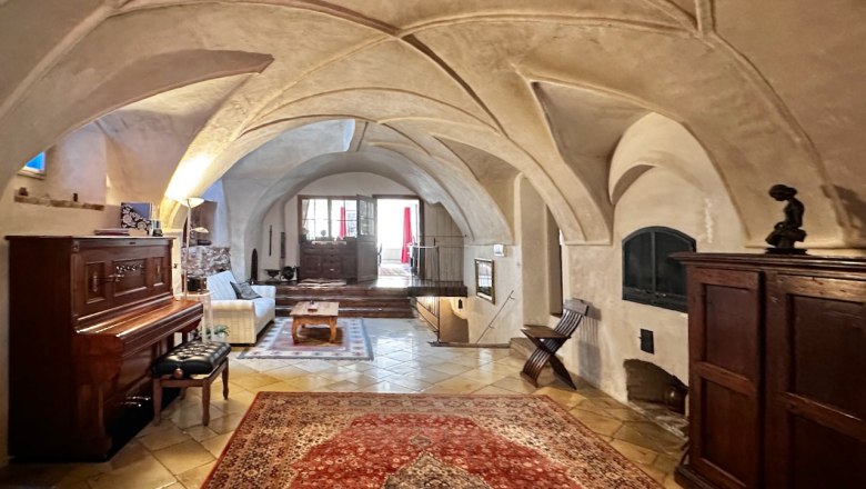 Historische Empfangshalle mit Gew&ouml;lbedecke, Teppich, Klavier und Holzm&ouml;beln.