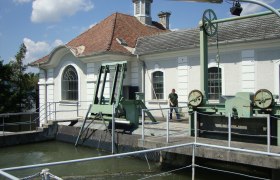 Außenansicht des EVN Schaukraftwerks Ungarfeld mit Wasser und Maschinen.