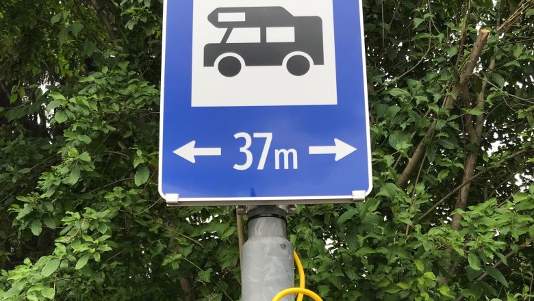 A blue traffic sign with a motorhome symbol and the words '37 m' with arrows pointing left and right.