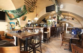 Innenansicht eines gem&uuml;tlichen Pubs mit Holzm&ouml;beln und Bar.