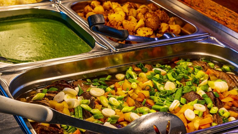Buffet mit verschiedenen Speisen in Edelstahlbehältern.