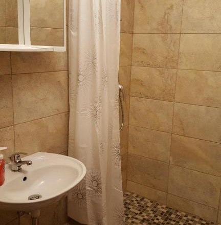 Badezimmer mit Duschbereich, Waschbecken und Duschvorhang.