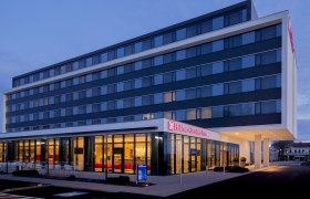 Außenansicht eines modernen Hotels bei Dämmerung.