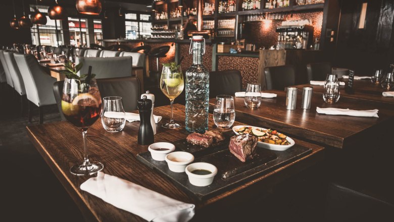 Elegant restaurant with table setting, drinks and food.